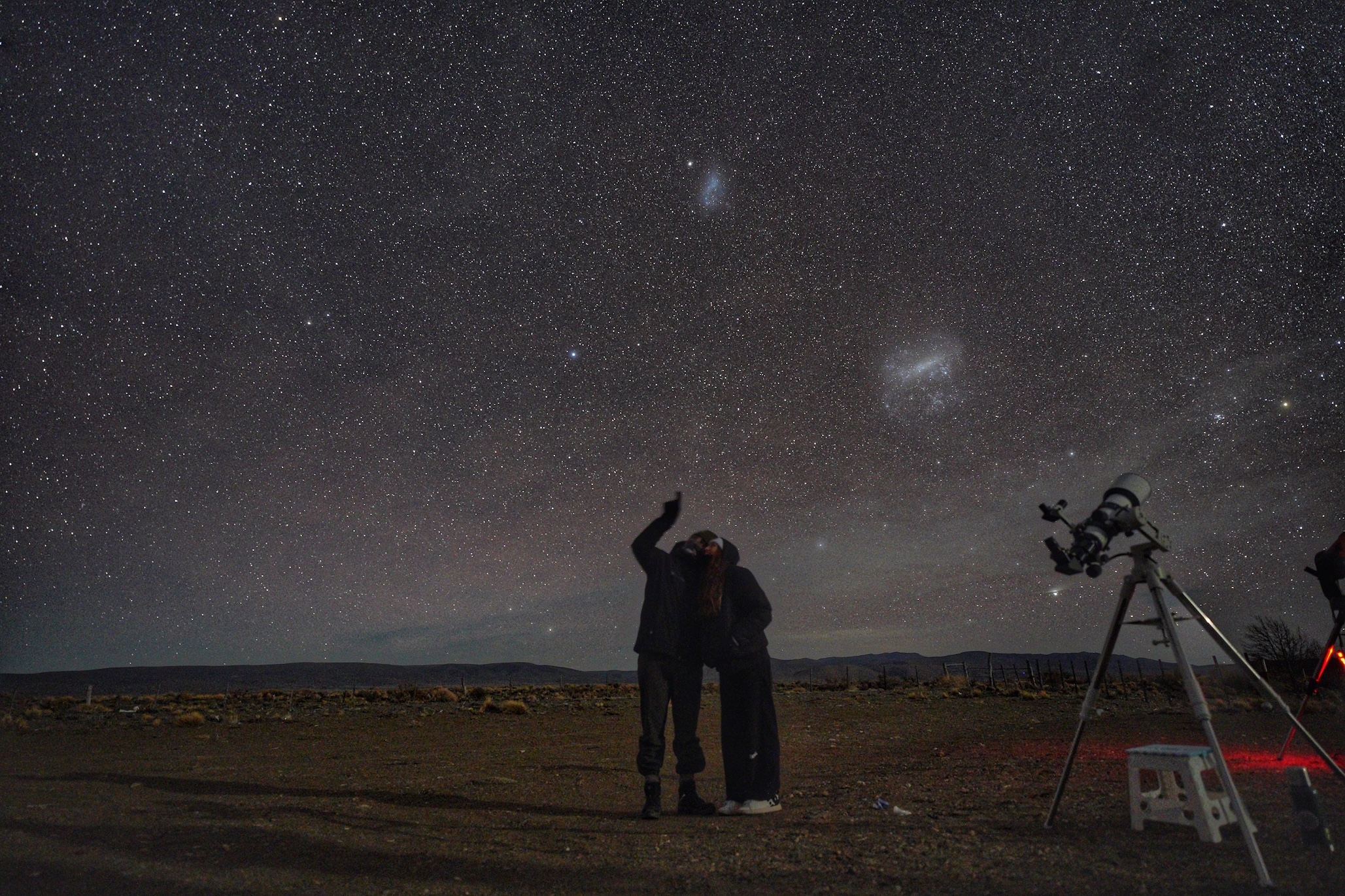 Pareja contemplando las Nubes de Magallanes en una salida agreste de astroturismo